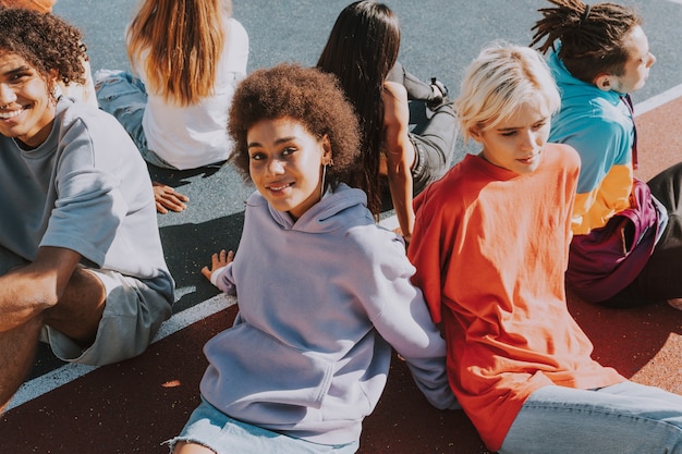 Gruppo multiculturale di giovani amici che si uniscono all'aperto e si divertono - ragazzi alla moda e alla moda che si riuniscono allo skate park urbano