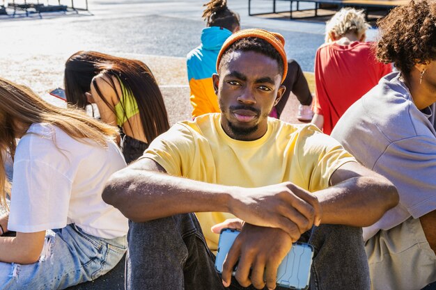 Gruppo multiculturale di giovani amici che si uniscono all'aperto e si divertono - ragazzi alla moda e alla moda che si riuniscono allo skate park urbano