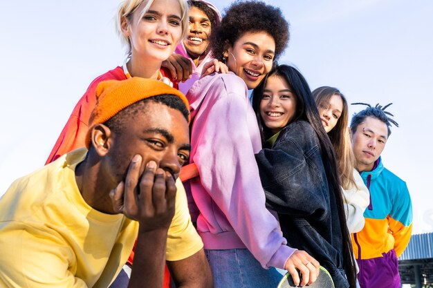 Foto gruppo multiculturale di giovani amici che si uniscono all'aperto e si divertono - ragazzi alla moda e alla moda che si riuniscono allo skate park urbano