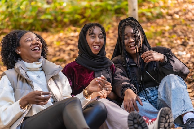 Photo multicultural group of young women having fun sitting on a park