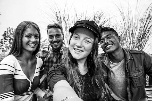 一緒に楽しい一日を過ごしている若い多民族の人々の幸せな友情の概念屋外で自分撮りをしている多文化の男と女