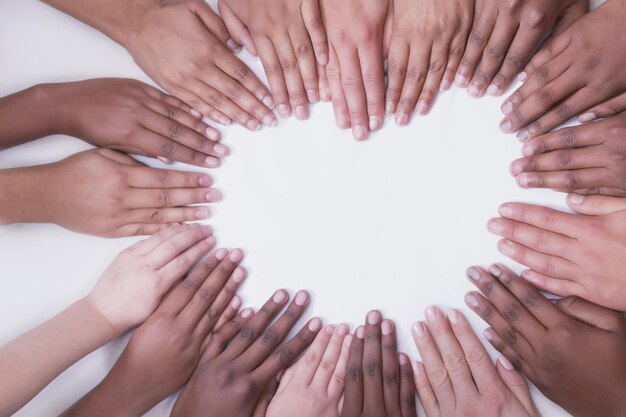 Multicultural hands on a white backdrop in a heart shape