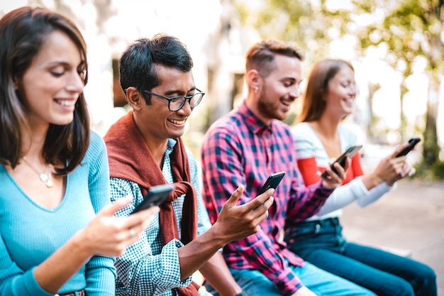 Multicultural students laughing using smartphone at university college campus