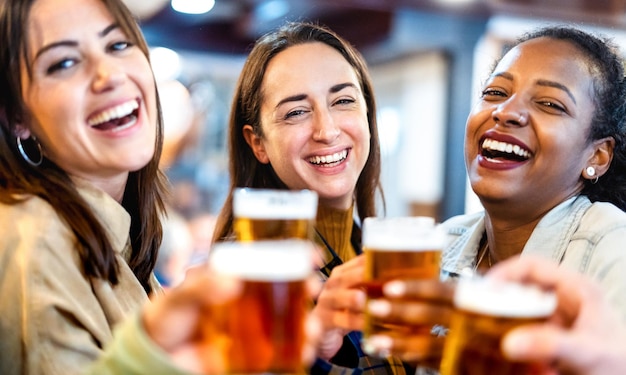 Multiculturele vriendinnen die bier drinken in het restaurant van de brouwerijbar