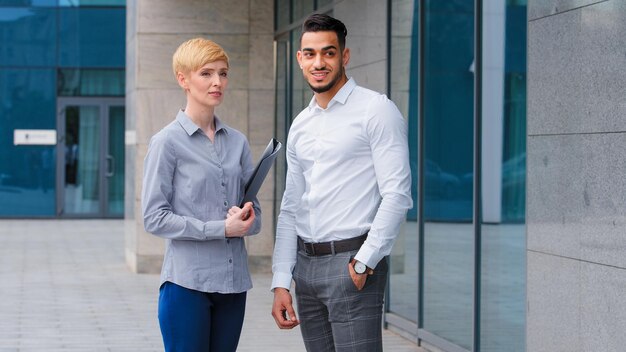 Multiethnic Arabic indian business man and caucasian woman holding folder taking break in work