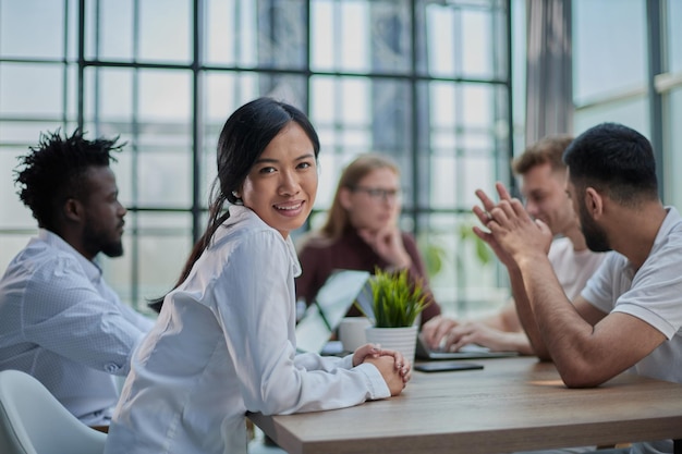 Multiethnic business partners having meeting at table with laptops in modern office