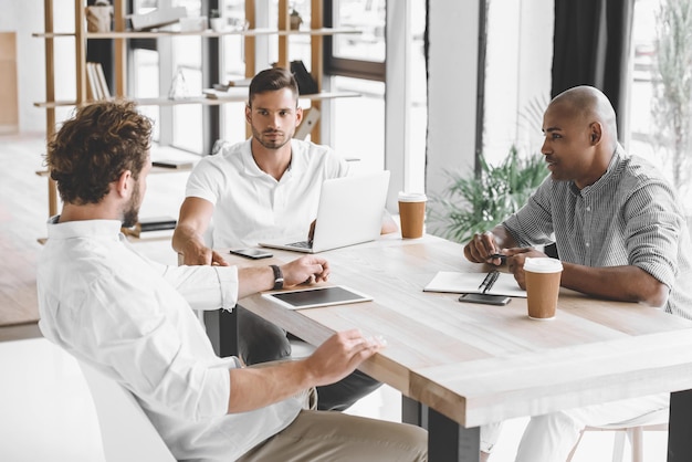 Photo multiethnic business people discussing business idea at meeting in office