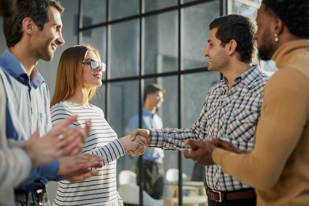 Multiethnic business people shaking hands in office lobby