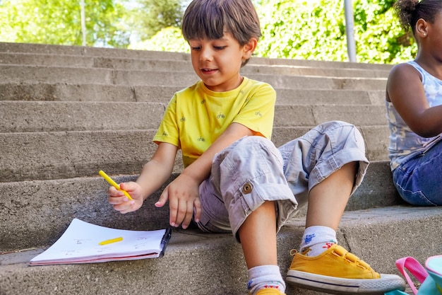 Multiethnic children doing homework at school entrance stairs