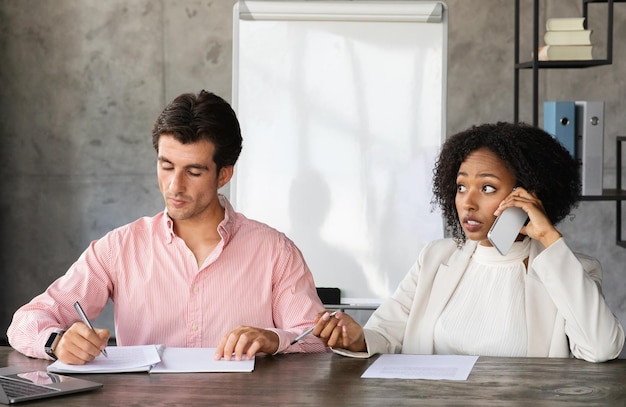 Multiethnic colleagues sitting at desk at office working on project