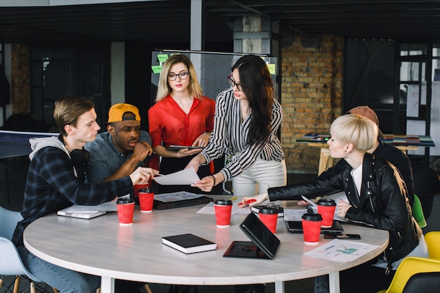 Multiethnic diverse group of creative team, casual business people, or college students in strategic meeting or project brainstorm discussion at office, using tablets. Startup or teamwork concept.