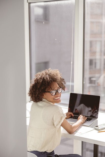 Multiethnic female worker using laptop at her workplace