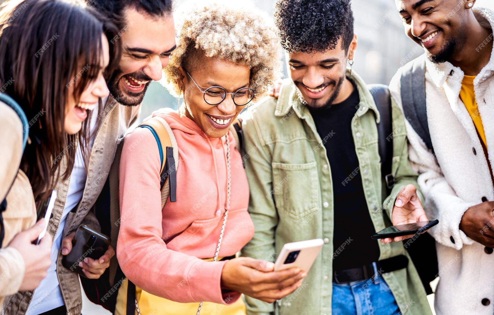 Premium Photo | Multiethnic friends having fun with mobile phone at college yard - young happy men and women spending time together sharing funny video on smartphone device - vivid filter with Premium Photo | Multiethnic friends having fun with mobile phone at college yard - young happy men and women spending time together sharing funny video on smartphone device - vivid filter with
