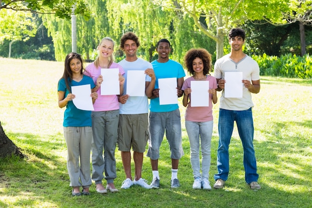 Multiethnic friends holding blank papers 