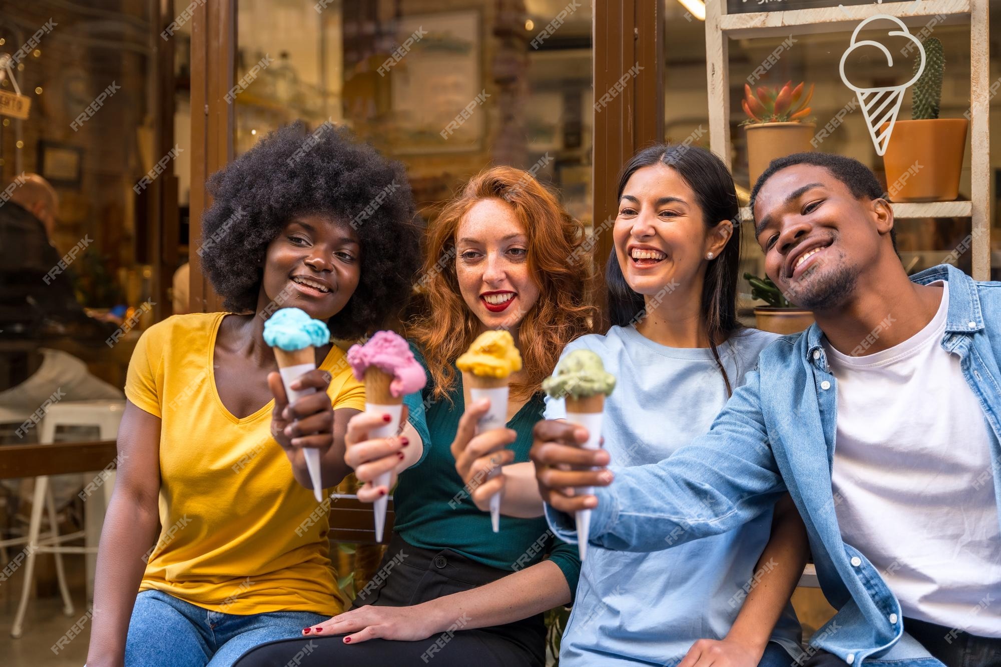 Premium Photo  Multiethnic friends in an ice cream parlor sitting eating  an ice cream summer showing off the ice creams