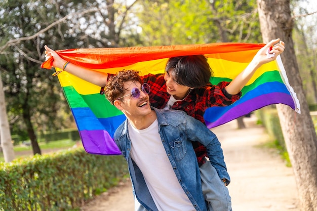 Multiethnic gay couple piggybacking in a park