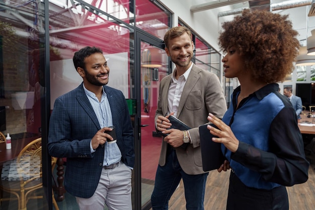 Photo multiethnic group of business people talking in office during break teamwork concept