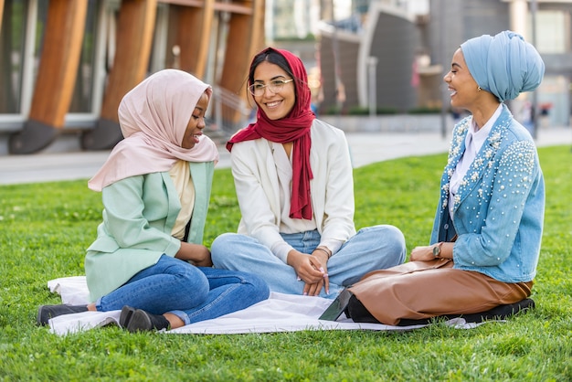 캐주얼 옷을 입고 야외에서 전통적인 히잡 결합을 하는 다민족 이슬람 소녀들
