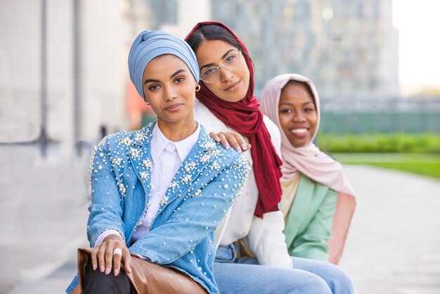 multiethnic group of muslim girls wearing casual clothes and traditional hijab bonding