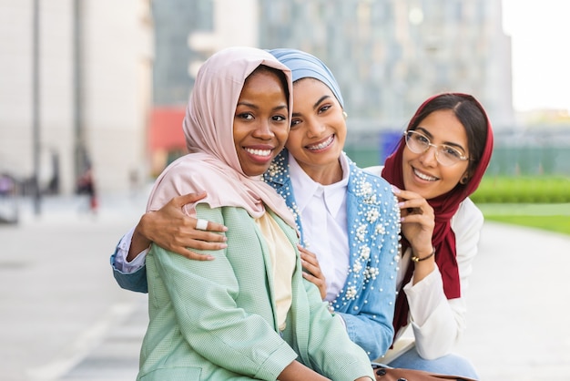 multiethnic group of muslim girls wearing casual clothes and traditional hijab bonding