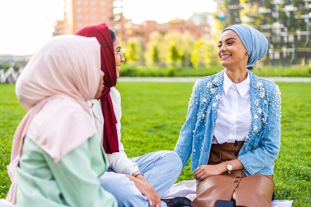 multiethnic group of muslim girls wearing casual clothes and traditional hijab bonding