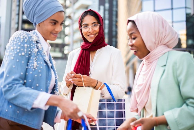 multiethnic group of muslim girls wearing casual clothes and traditional hijab bonding