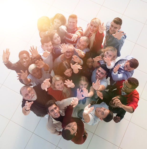 Multiethnic group of people standing together with hands up