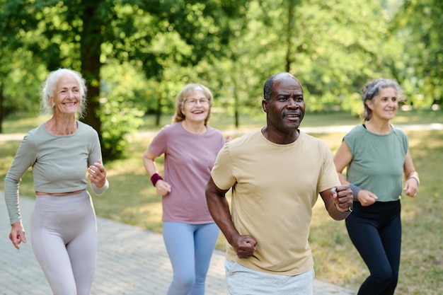 Foto gruppo multietnico di anziani che fanno jogging insieme nel parco