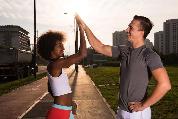 multiethnic group of young people on the jogging beautiful morning as the sun rises in the streets of the city