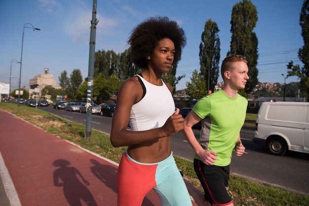 multiethnic group of young people on the jogging beautiful morning as the sun rises in the streets of the city