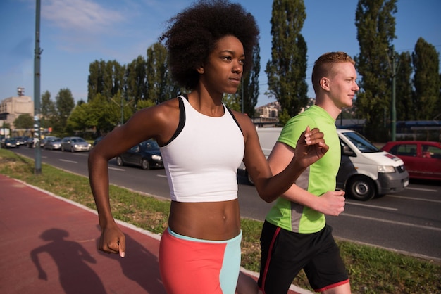 multiethnic group of young people on the jogging beautiful morning as the sun rises in the streets of the city