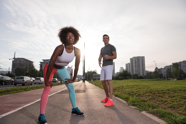 multiethnic group of young people on the jogging beautiful morning as the sun rises in the streets of the city