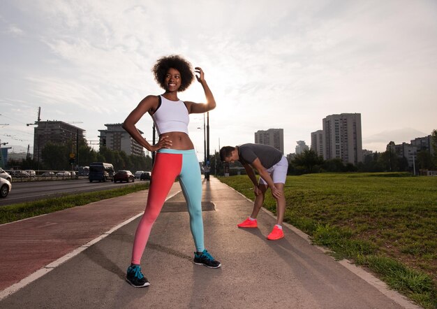 multiethnic group of young people on the jogging beautiful morning as the sun rises in the streets of the city