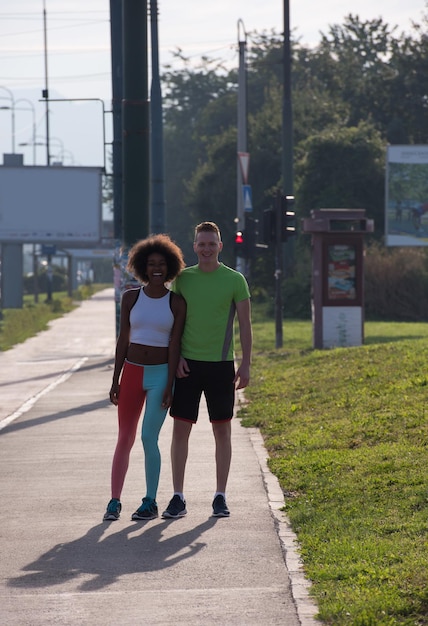 multiethnic group of young people on the jogging beautiful morning as the sun rises in the streets of the city