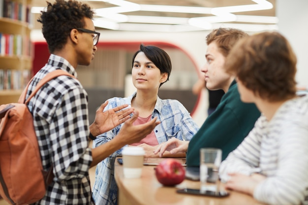 Foto amici multietnici del liceo che discutono progetto