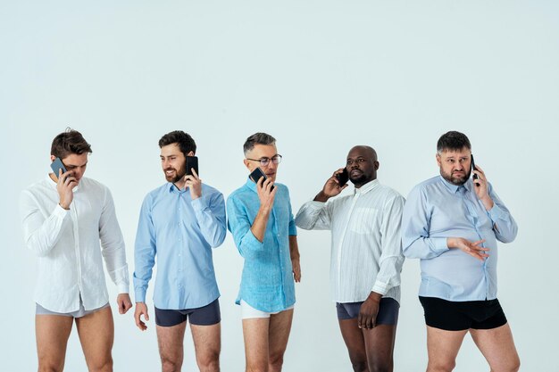 남성 에디션 바디 포지티브 뷰티 세트를 위해 포즈를 취하는 다민족 남성. 나이가 다른 남자들과 복서 속옷과 셔츠를 입은 몸