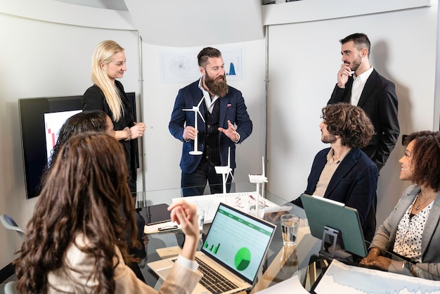 Multiethnic and multicultural business people working together on sustainable innovation project Green renewable energy concept Focus on elegant hipster man