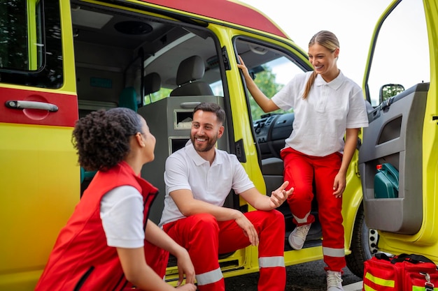 Foto paramedici multietnici in piedi davanti a un'ambulanza medico di emergenza e infermiere in piedi davanti all'ambulanza