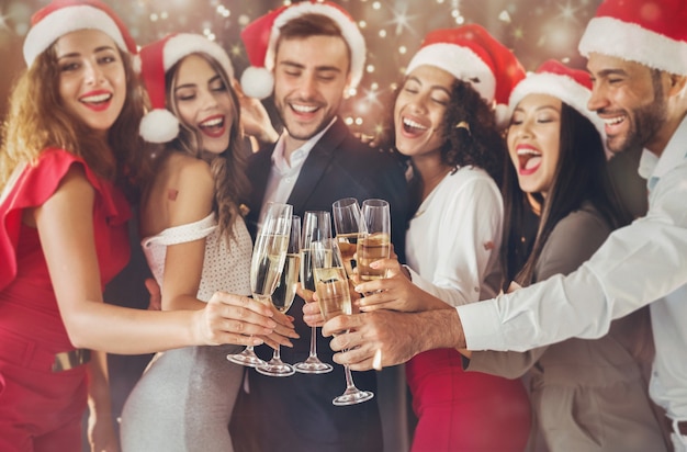 Persone multietniche che festeggiano il capodanno, brindando con flauti di champagne, applausi, evviva