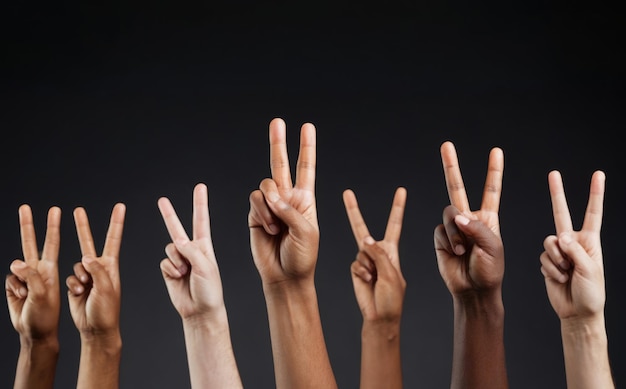 Photo multiethnic people show a peace sign with their hands