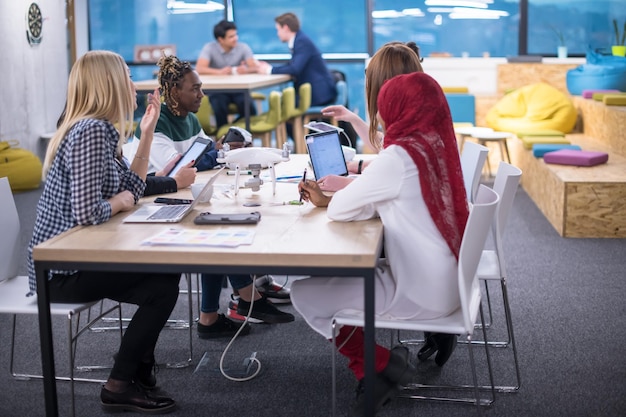 multiethnic startup business team discussing new business plan,working on laptop and tablet computer while learning about drone technology for new business advancement