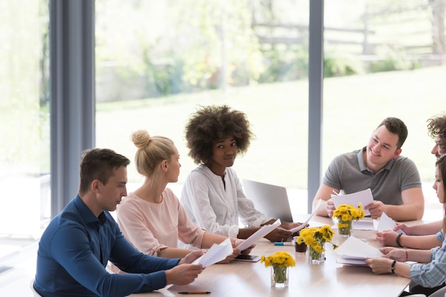 Multiethnic startup business team on meeting in modern bright office interior brainstorming, working on laptop and tablet computer