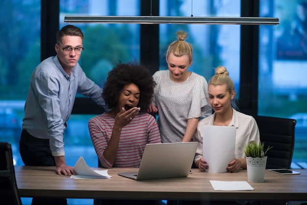 현대적인 야간 사무실 내부 브레인스토밍에서 회의를 하는 다민족 스타트업 비즈니스 팀, 노트북 작업