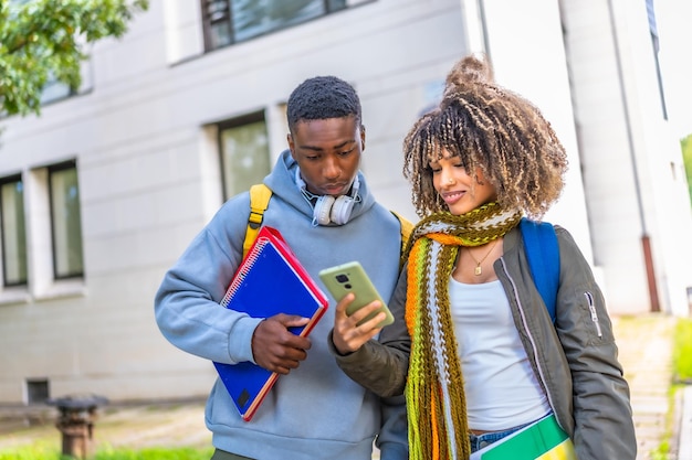 multiethnic students using mobile standing outside the campus