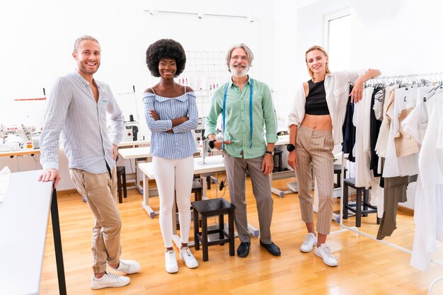 Multiethnic team of fashion designers working in a clothing start-up workshop - Multiracial group of stylists, tailor designers and dressmakers working on a new collection