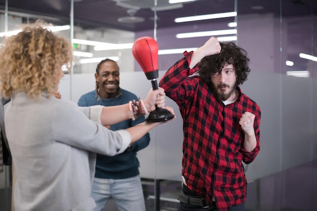 multiethnics startup business team of software developers having fun while boxing at office,excited diverse employees laughing enjoying funny activity at work break, creative friendly workers playing