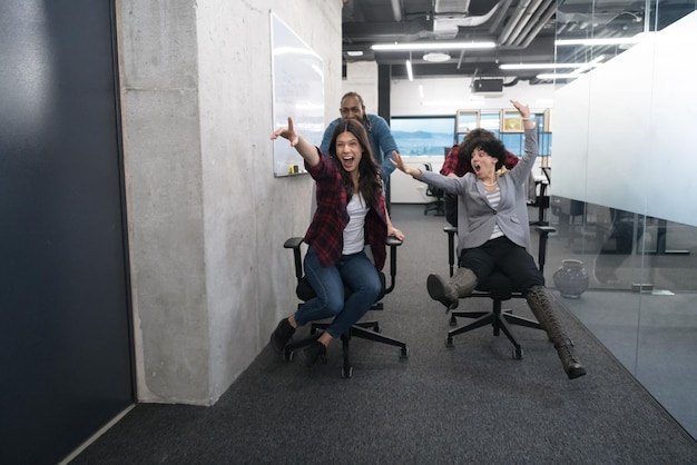 multiethnics startup business team of software developers having fun while racing on office chairs,excited diverse employees laughing enjoying funny activity at work break, creative friendly workers p