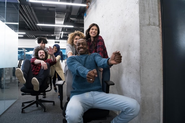 multiethnics startup business team of software developers having fun while racing on office chairs,excited diverse employees laughing enjoying funny activity at work break, creative friendly workers p