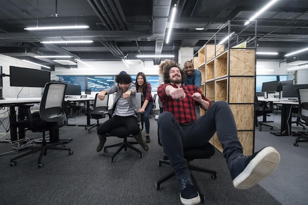 multiethnics startup business team of software developers having fun while racing on office chairs,excited diverse employees laughing enjoying funny activity at work break, creative friendly workers p