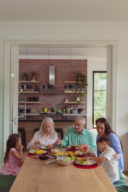 Foto famiglia multigenerazionale con cibo sul tavolo da pranzo a casa